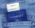 Passport and boarding pass in back pocket of blue jeans.